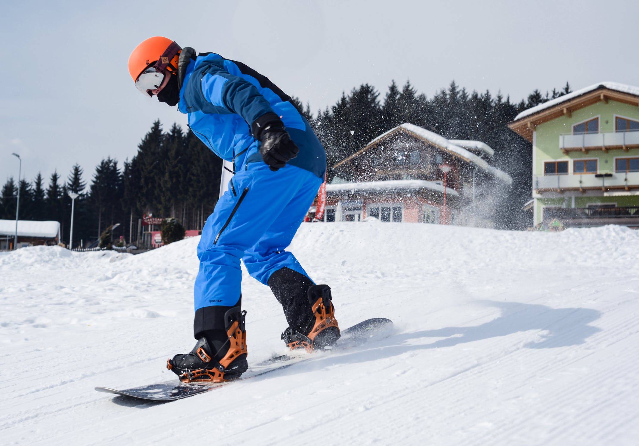Snowboarder performing a trick against a snowy Mt. Buller backdrop.