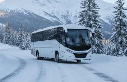 Modern tour bus parked in a snowy alpine setting at Mt Buller